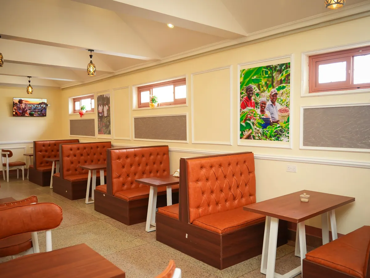 Orange booths and framed coffee farm photos inside the cafe