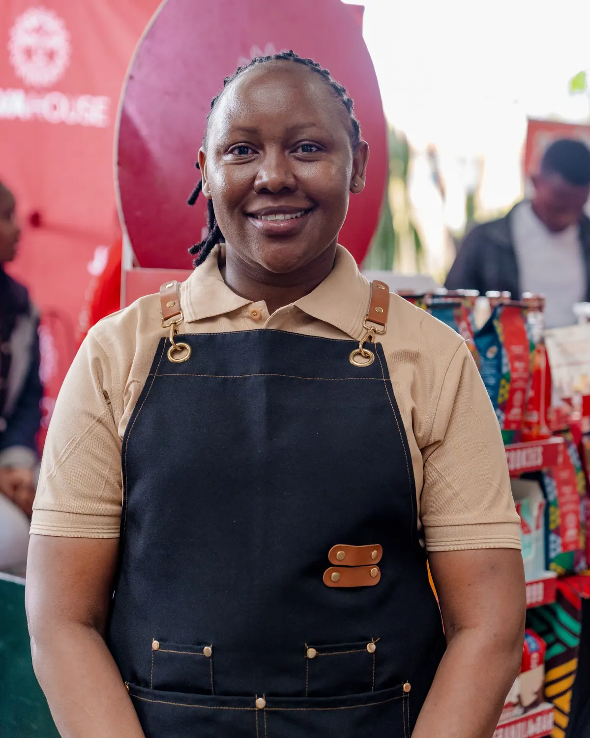 A smiling barista in a black apron