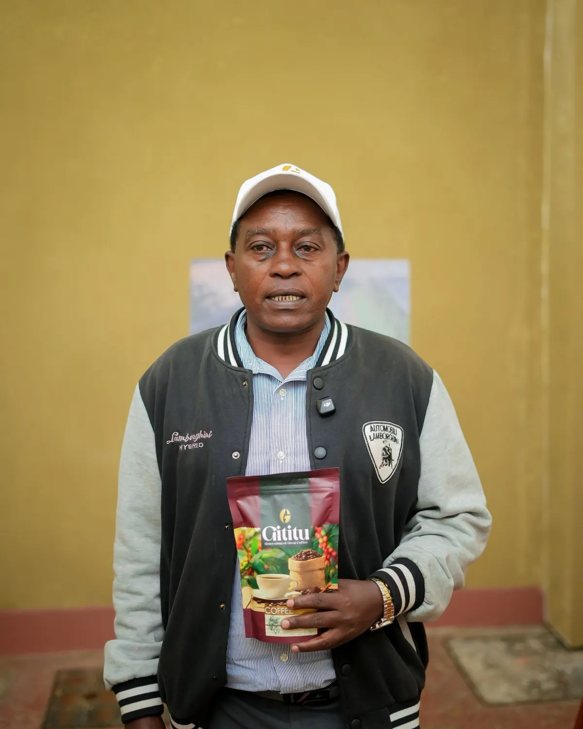 A man holding a pack of Gititu coffee