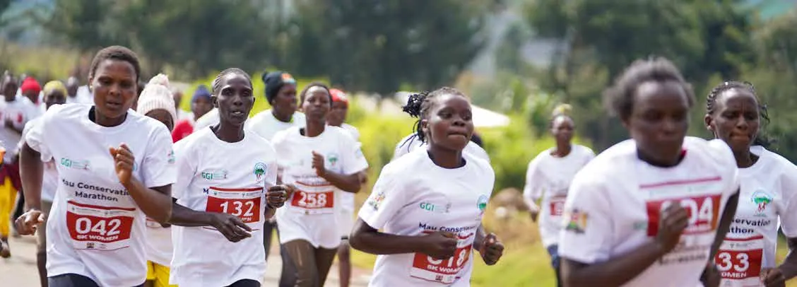 Runners in numbered bibs racing on a road