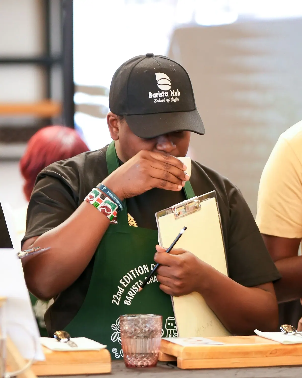 A judge in a Barista Hub cap tasting, clipboard in hand