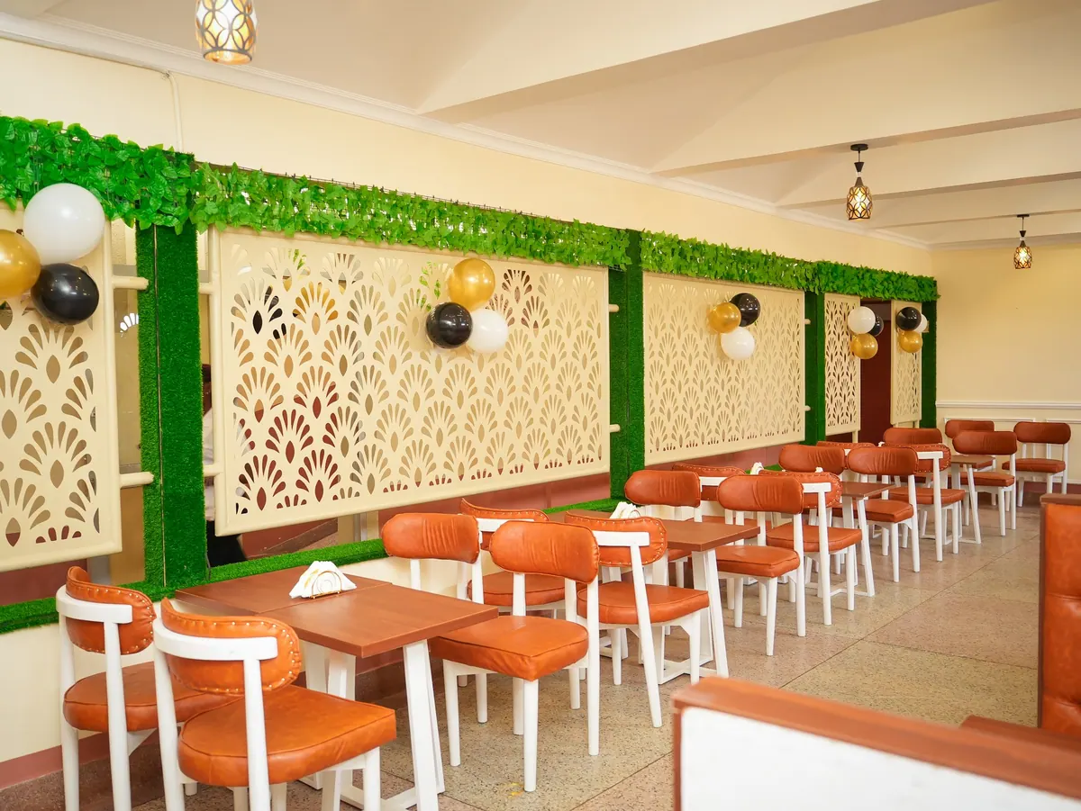 The cafe interior with orange chairs and a green lattice wall